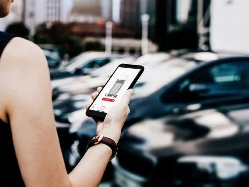 2024 Mitsubishi Outlander PHEV view of woman holding phone using connect system