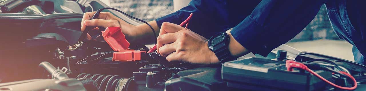 Close up view of a service tech working on a car battery